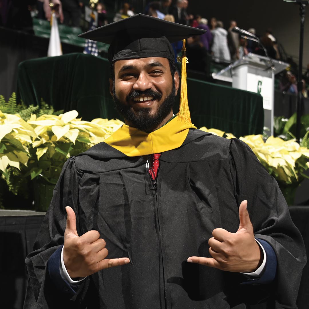 Graduate holds up two Niner pickaxes