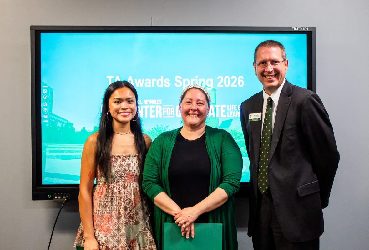 Student award winners pose with Dean Tolone at the front of a classroom and smile